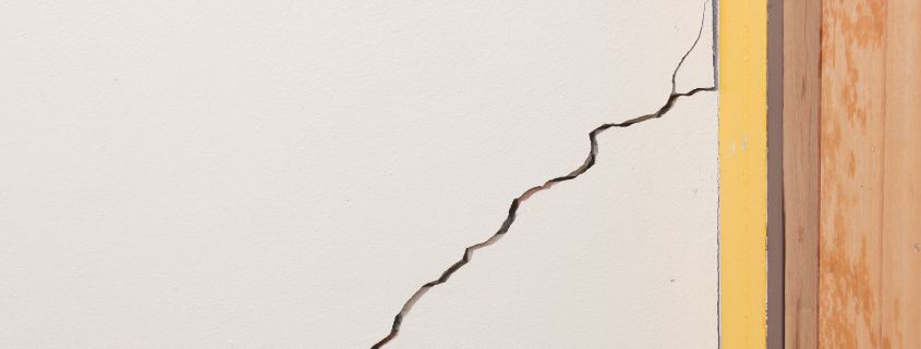 Crack in a wall going up to the frame of a door