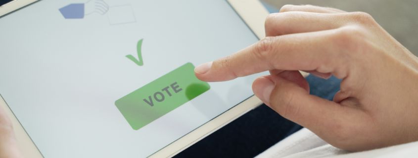 Persons hand clicking vote button on an electronic device