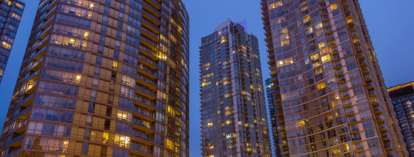 Photo of condo buildings in the evening with the windows lit from inside