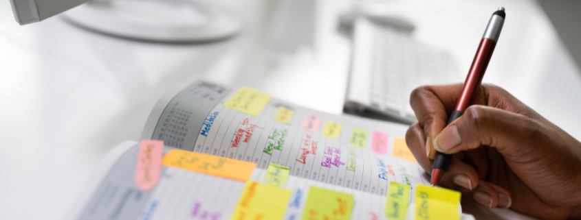 Image of a woman writing on a planner